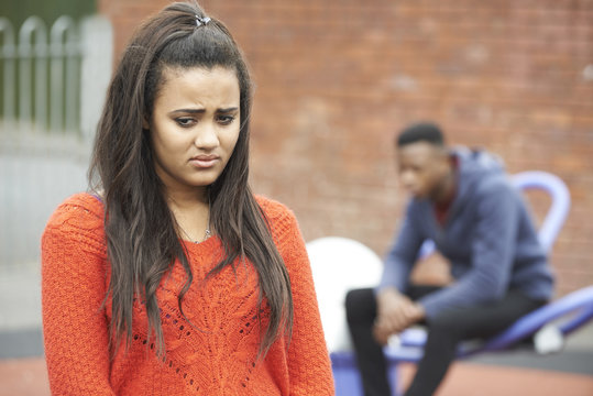 Portrait Of Unhappy Teenage Couple In Urban Setting