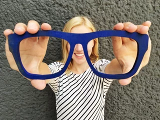 Muurstickers Mädchen hält Brille vor Augen © Robert Kneschke