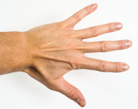 Male person showing five fingers towards a grey scale wall