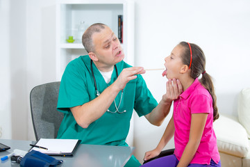 Pediatrician checking little girl throat