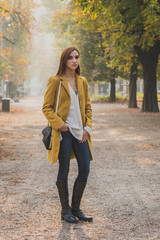 Redhead girl posing in a city park