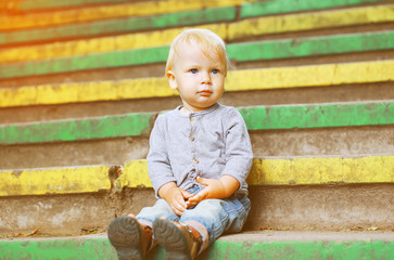 Little child sitting outdoors summer