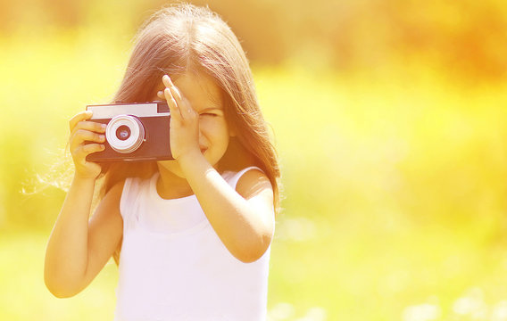 Child and retro vintage camera outdoors