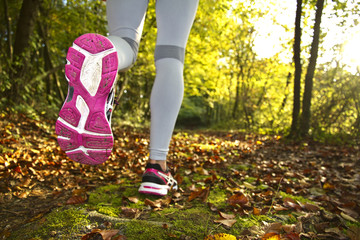 Fitness Girl running at sunset in forest