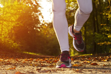 Fitness Girl running at sunset in forest