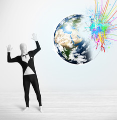 Funny man in body suit looking at colorful splatter earth