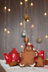 Smiling gingerbread man and a smaller one next to him standing i