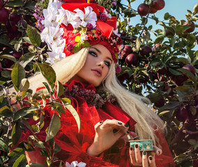Fashion image of sensual girl in bright red fantasy stylization.