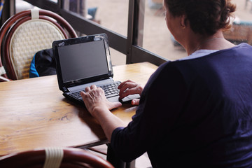 senior woman sitting on the cafe with laptop