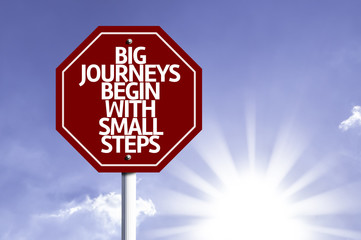 Big Journeys Begin With Small Steps written on red road sign