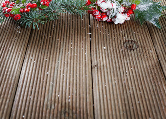 Holly leaves and berries on a wooden background