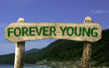 Forever Young sign with a beach on background