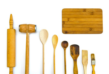 row of wooden kitchen utensils with a cutting board