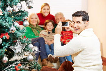 Mann macht Foto von Familie zu Weihnachten