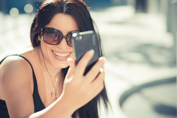 Naklejka premium beautiful long black hair elegant business woman using smartphon