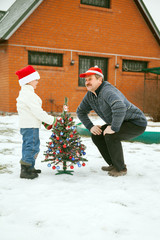 Grandfather and grandson  decorate a Christmas tree