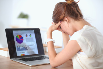 Portrait of tired young business woman with laptop computer at