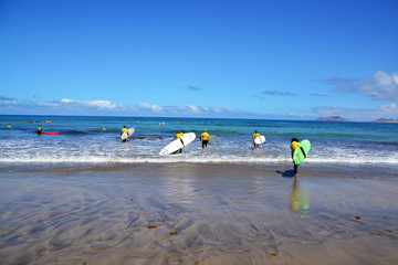grupo de surfistas  en playa famara