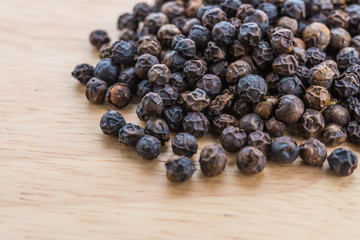 Black pepper on wood background