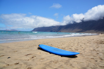 Fototapeta na wymiar tabla de surf en la playa de famara en la isla de lanzarote