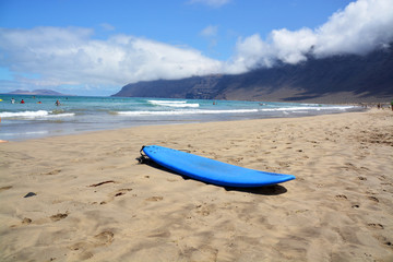 Fototapeta na wymiar tabla de surf en la playa de famara en la isla de lanzarote