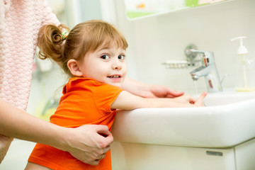 Fototapeta na wymiar kid girl washing hands with mom help