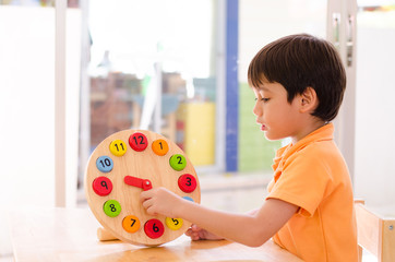 Little boy learning time with clock toy of montessori 