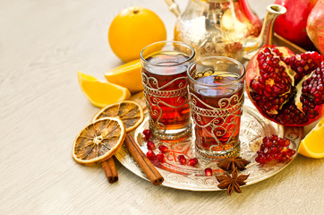 Traditional arabic tea with metal teapot pomegranate and spices