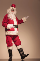 Santa Claus presenting something on his left