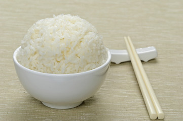 White steamed rice in ceramic bowl and chopsticks