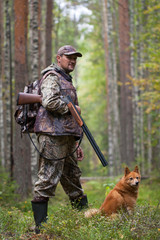 hunter with a dog in the  pine forest