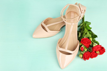 Beautiful woman shoes with flowers on wooden background