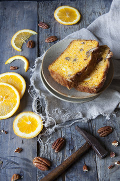 citrus cake on plate with pecan walnuts and orange slices