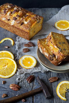 citrus cake on plate with pecan walnuts and orange slices