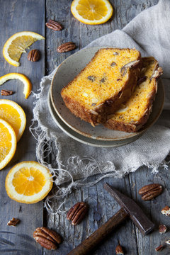 two slices of citrus cake on table with hammer and orange slices