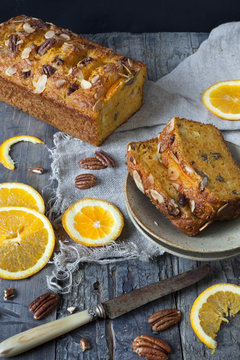 two slices of citrus cake on table with knife and orange slices