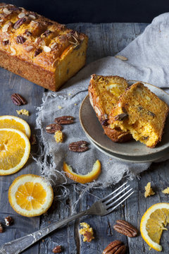 two slices of citrus cake on table with fork and orange slices