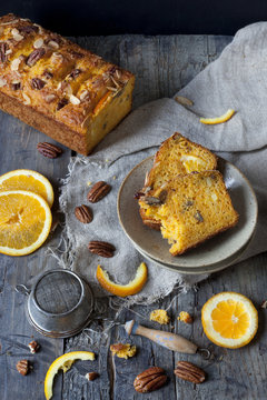 two slices of citrus cake with strainer and orange slices