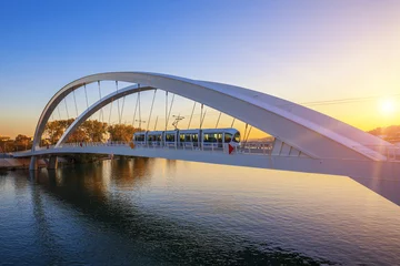 Foto auf Glas Straßenbahn auf der Brücke bei Sonnenuntergang © Frédéric Prochasson