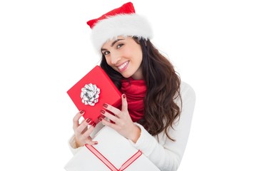 Smiling brunette holding christmas gifts