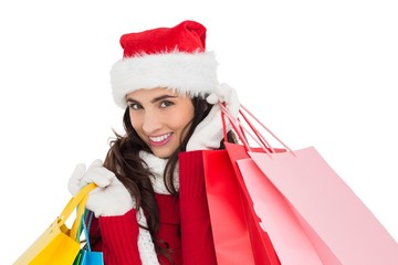 Festive brunette in winter wear holding shopping bags