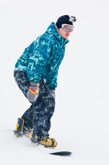 Teen snowboarder in blue jacket on the board