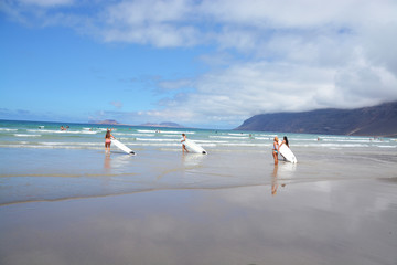 surfista saliendo del agua en playa famara, lanzarote