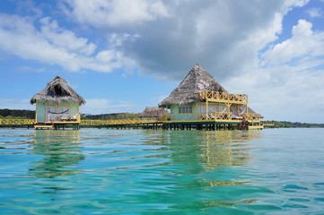 Tropical bungalows over water with thatch roof