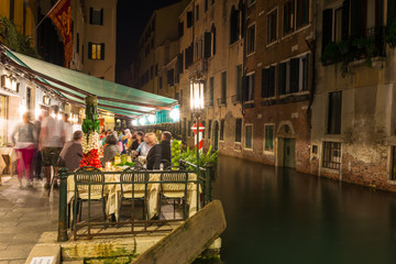Fototapeta premium Night view of canal and restaurant in Venice, Italy
