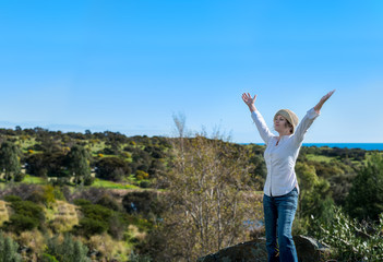 Fototapeta premium Woman in nature with arms outstretched