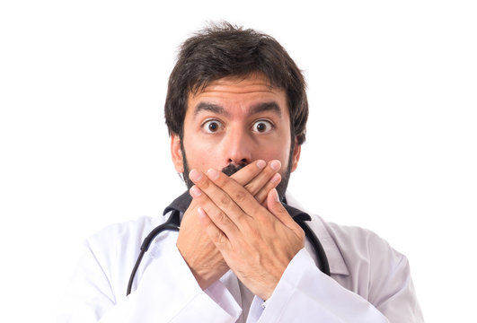 Doctor doing surprise gesture over white background