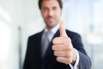 Businessman giving thumbs up - obrazy, fototapety, plakaty