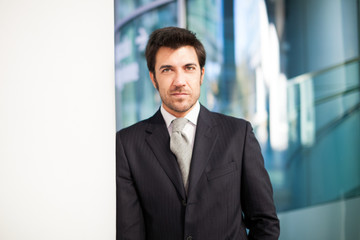 Fototapeta premium Businessman leaning on a wall