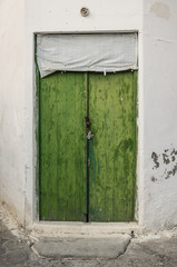 Old green timber door in the scuffed wall